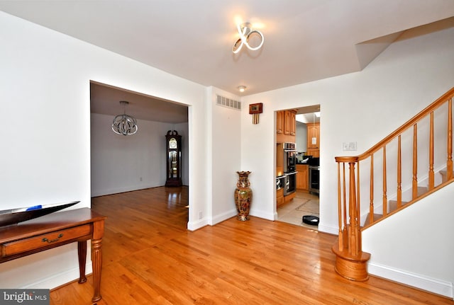 entrance foyer with a notable chandelier and light hardwood / wood-style flooring