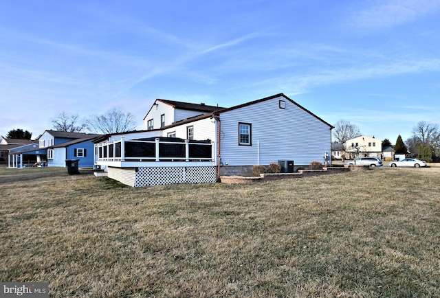 view of home's exterior with a sunroom and a yard