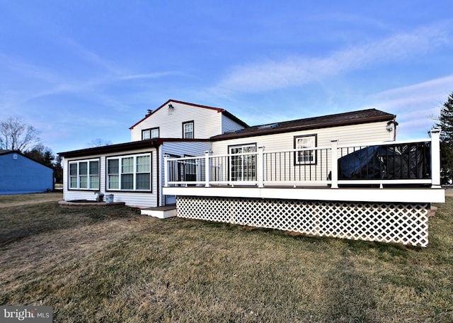 rear view of house featuring a wooden deck and a yard