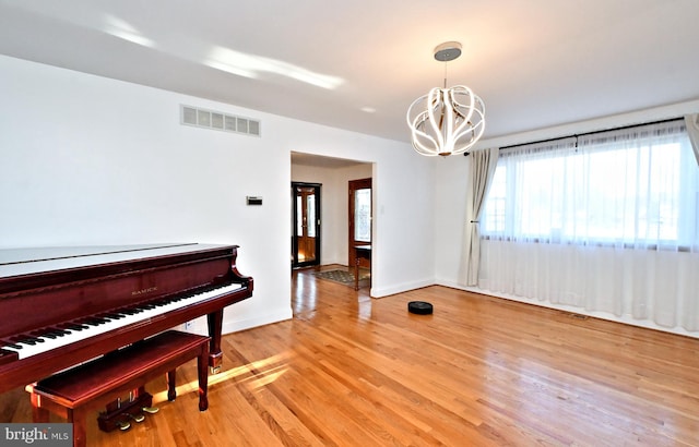 misc room featuring a chandelier and light hardwood / wood-style flooring