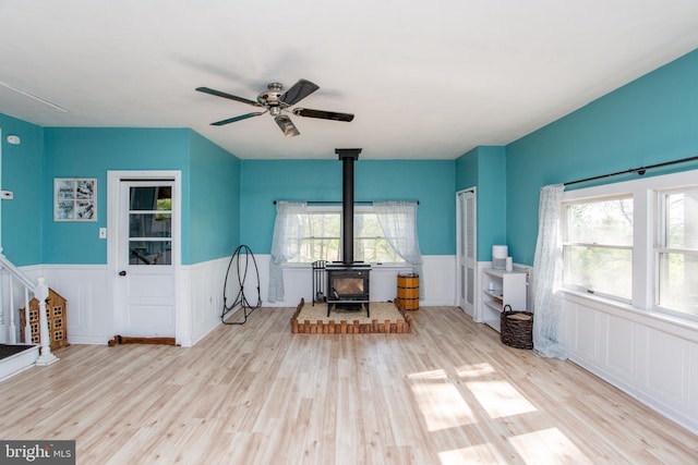 432 Swartley Rd, Hatfield, PA 19440 - interior space with a wood stove, a wainscoted wall, a ceiling fan, a wealth of natural light, and wood finished floors