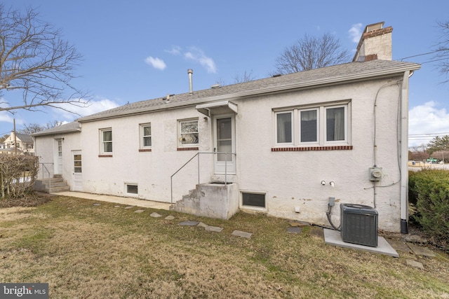 back of house with cooling unit and a yard