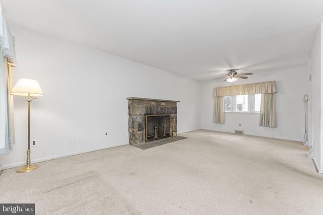 unfurnished living room featuring ceiling fan, a fireplace, and light carpet