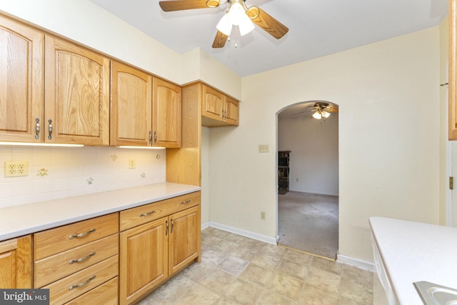 kitchen featuring light carpet, decorative backsplash, and ceiling fan