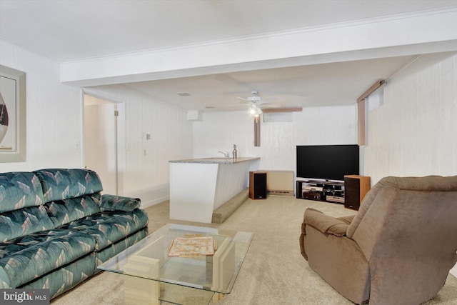 living room with ceiling fan, ornamental molding, and light carpet