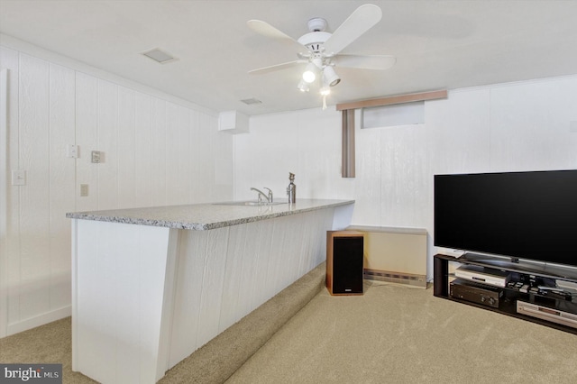 kitchen with sink, light carpet, and ceiling fan