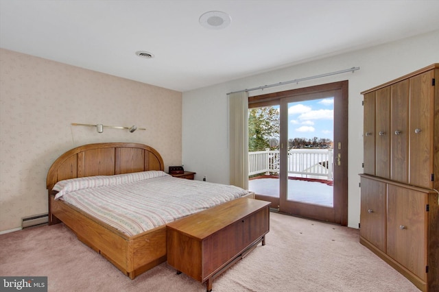 carpeted bedroom with access to exterior and a baseboard heating unit