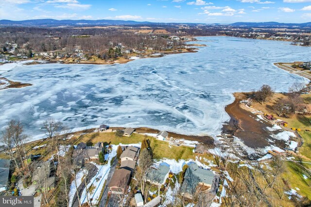 snowy aerial view with a water and mountain view