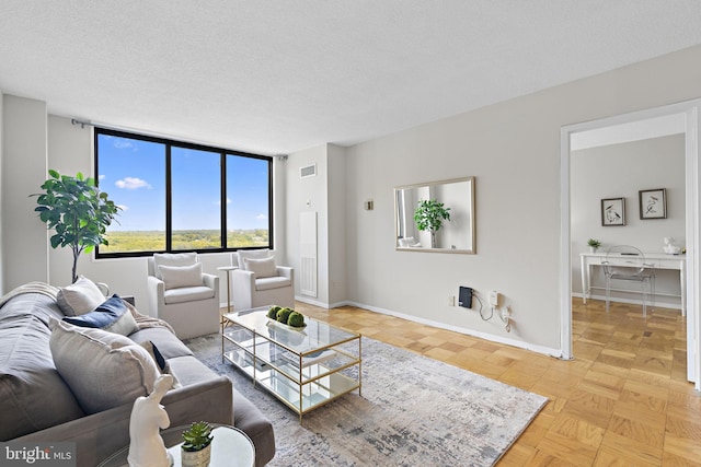 living room with light parquet flooring and a textured ceiling