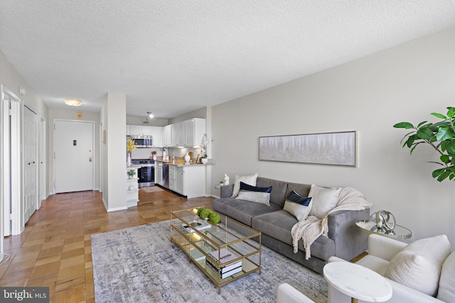 living room featuring parquet flooring and a textured ceiling