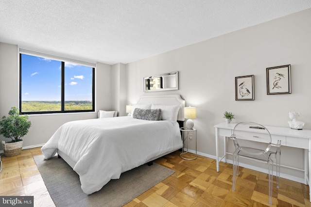 bedroom with parquet floors and a textured ceiling