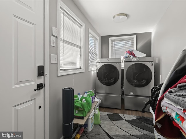 clothes washing area with separate washer and dryer and dark hardwood / wood-style floors