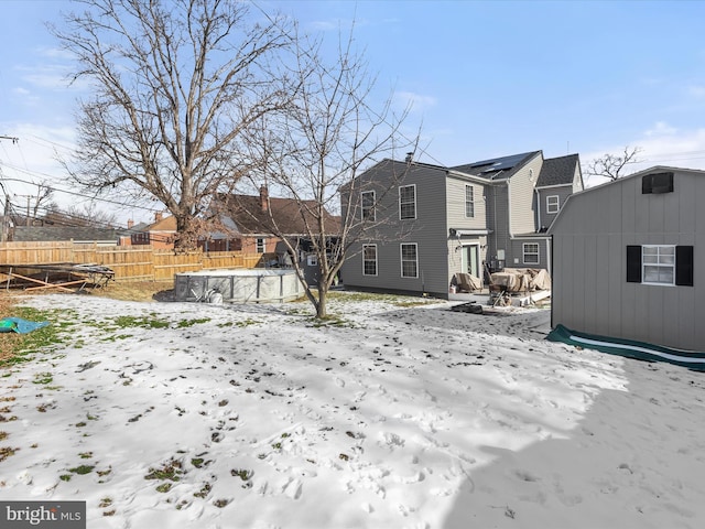 snowy yard with a trampoline and an outbuilding