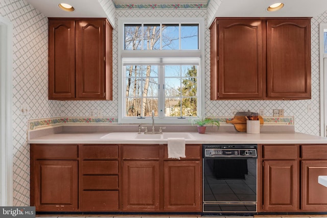 kitchen with black dishwasher, light countertops, brown cabinets, and wallpapered walls