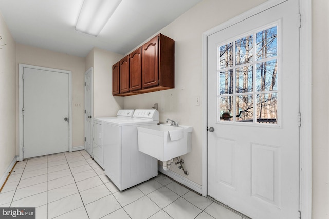 laundry area with a wealth of natural light, washing machine and dryer, cabinet space, and a sink