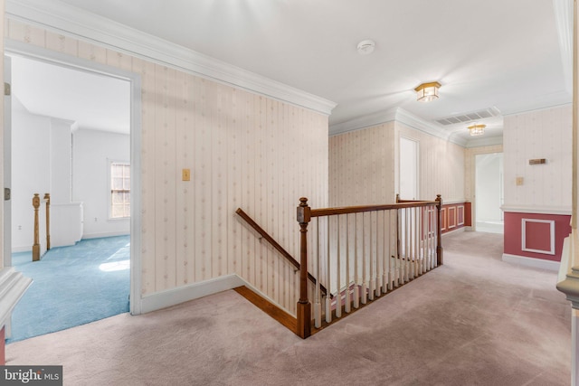 hallway featuring visible vents, an upstairs landing, and wallpapered walls