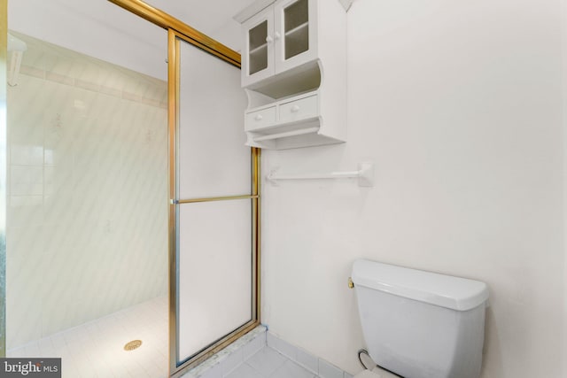 full bathroom featuring a stall shower, toilet, and baseboards