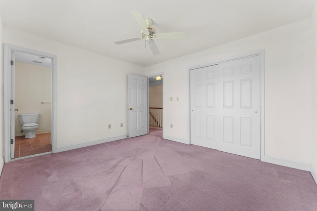 unfurnished bedroom featuring carpet, a closet, a ceiling fan, connected bathroom, and baseboards