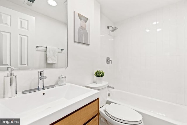 full bathroom featuring tiled shower / bath combo, vanity, and toilet