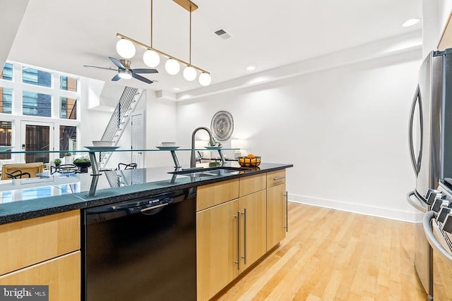 kitchen featuring decorative light fixtures, dishwasher, sink, light brown cabinets, and light hardwood / wood-style flooring