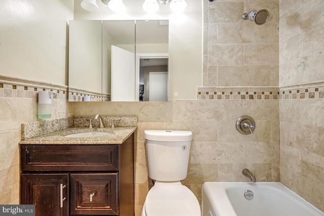 full bathroom featuring tiled shower / bath combo, vanity, tile walls, and toilet