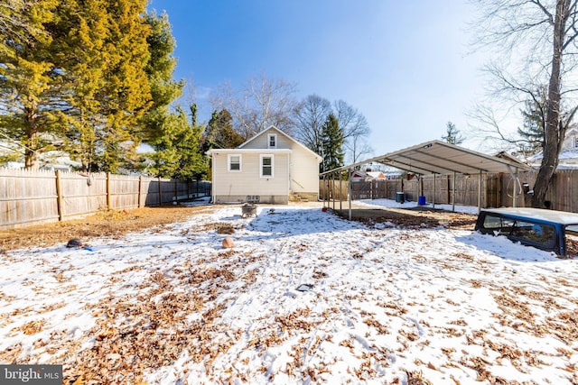 snowy yard with a carport