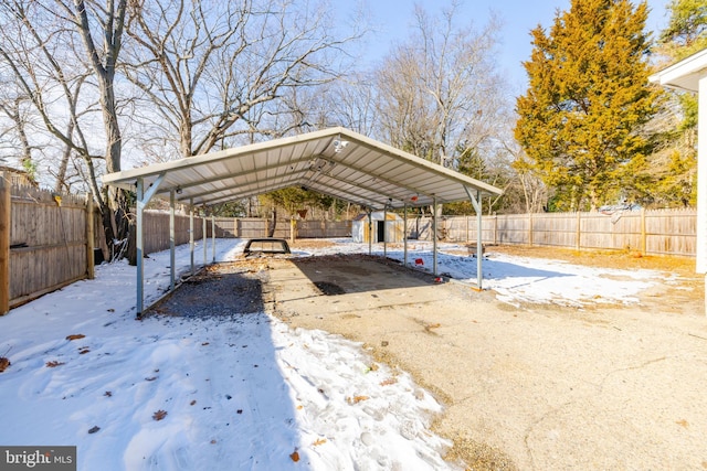 snow covered parking featuring a carport