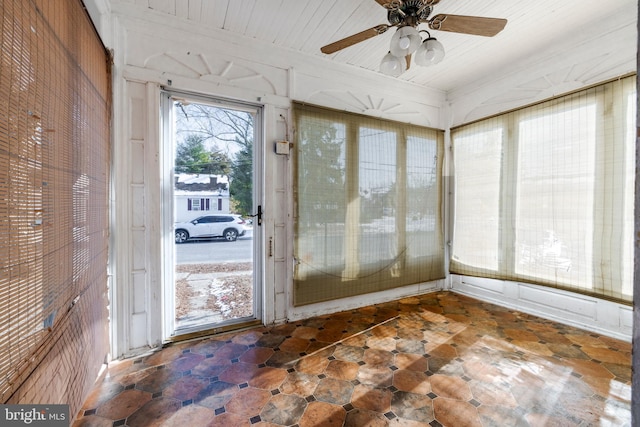 unfurnished sunroom featuring ceiling fan