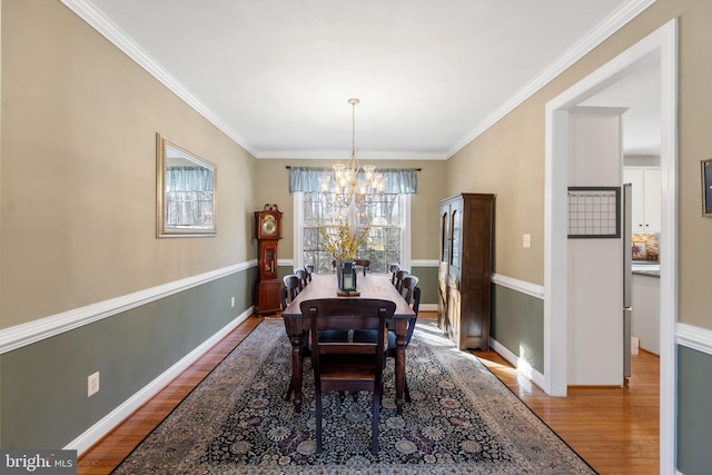 dining room featuring an inviting chandelier, crown molding, and hardwood / wood-style floors