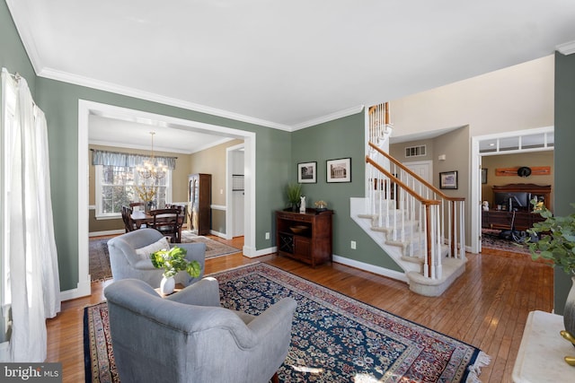 living room featuring crown molding, hardwood / wood-style flooring, and a chandelier