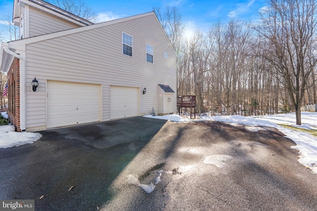 view of snowy exterior featuring a garage