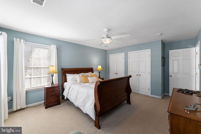 carpeted bedroom featuring two closets and ceiling fan