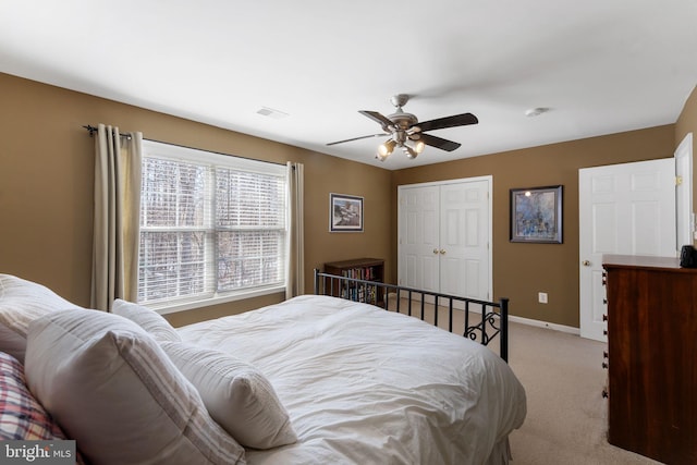 bedroom featuring ceiling fan, light colored carpet, and a closet