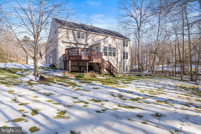 snow covered house featuring a wooden deck