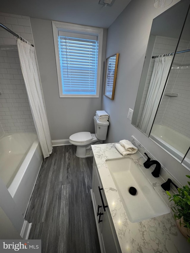 full bathroom with vanity, hardwood / wood-style floors, toilet, and shower / bathtub combination with curtain