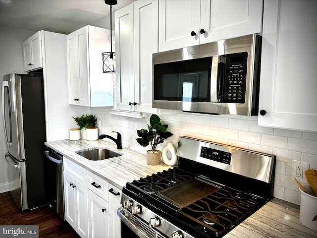 kitchen featuring light stone counters, white cabinetry, tasteful backsplash, and stainless steel appliances