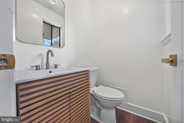 bathroom featuring vanity, toilet, and wood-type flooring