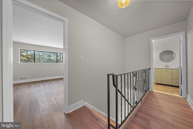 hallway with wood-type flooring and sink