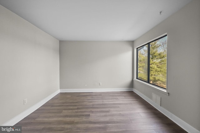 unfurnished room with dark hardwood / wood-style flooring