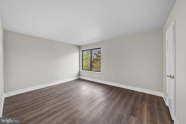 unfurnished room featuring dark wood-type flooring