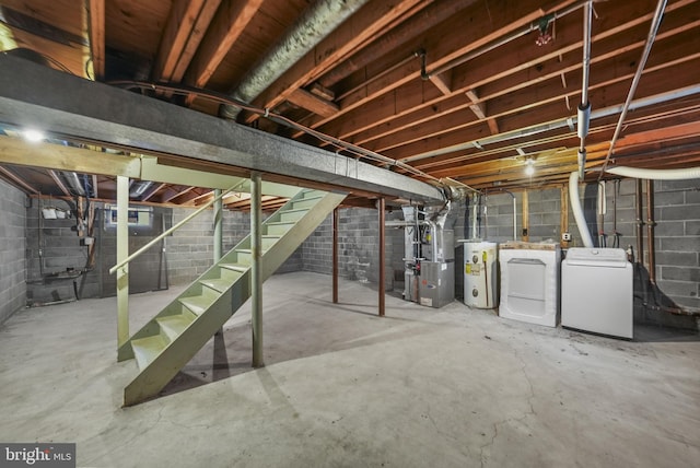 basement featuring water heater, heating unit, and independent washer and dryer