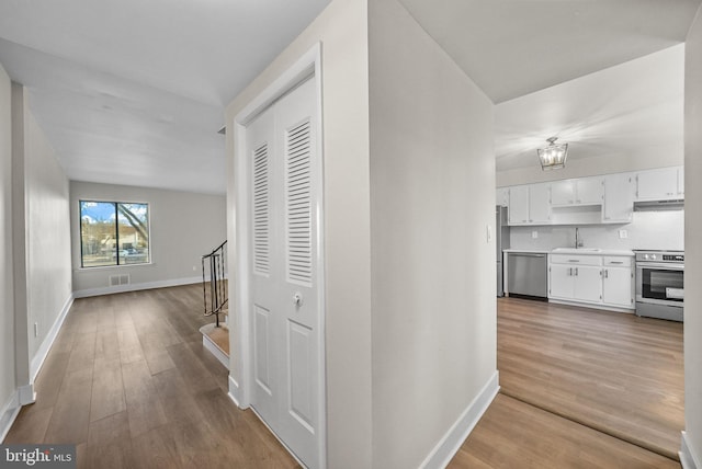 hall with wood-type flooring and sink