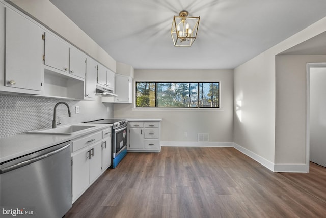 kitchen with pendant lighting, sink, appliances with stainless steel finishes, white cabinetry, and tasteful backsplash