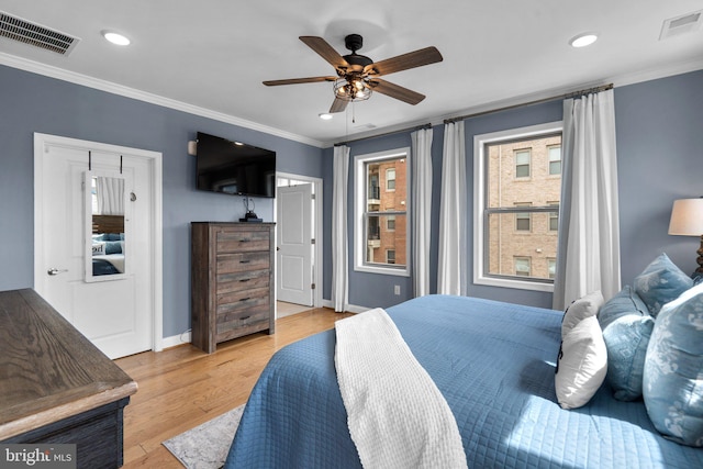 bedroom with ornamental molding, ceiling fan, and light wood-type flooring