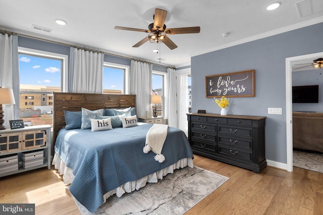 bedroom featuring multiple windows, ornamental molding, ceiling fan, and light hardwood / wood-style flooring