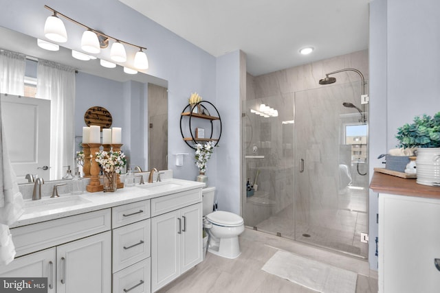 bathroom featuring vanity, toilet, and a shower with shower door