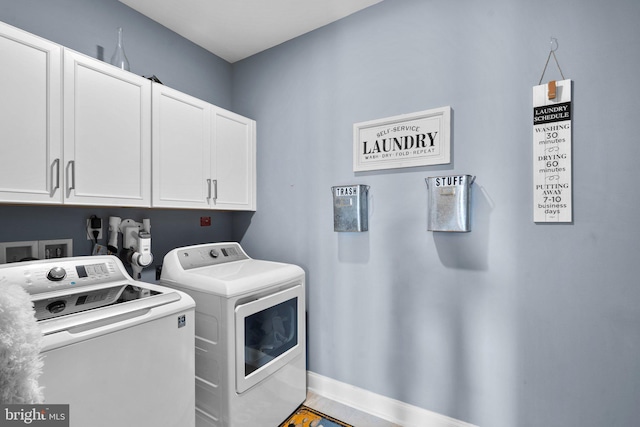 clothes washing area featuring cabinets and washing machine and clothes dryer