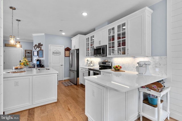 kitchen with white cabinetry, appliances with stainless steel finishes, sink, and pendant lighting