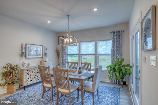 dining room with dark wood-type flooring and a chandelier