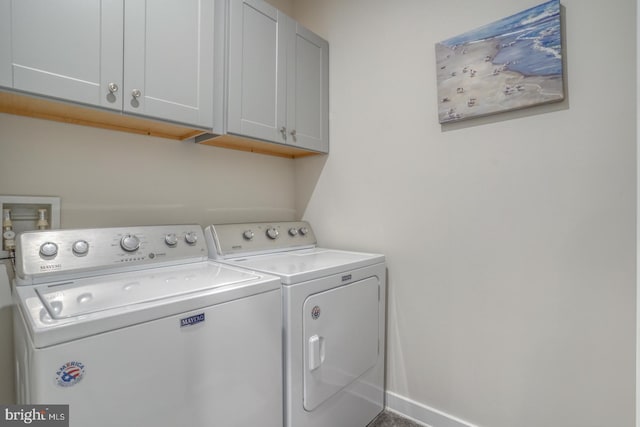 washroom featuring washer and clothes dryer and cabinets